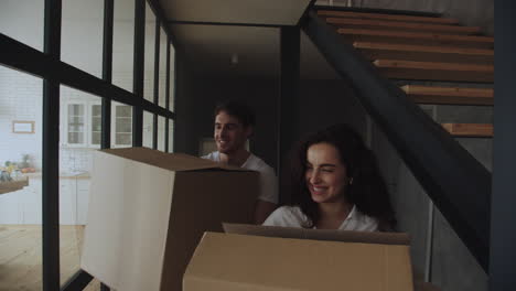 Smiling-man-and-woman-putting-paper-boxes-on-floor-in-slow-motion.