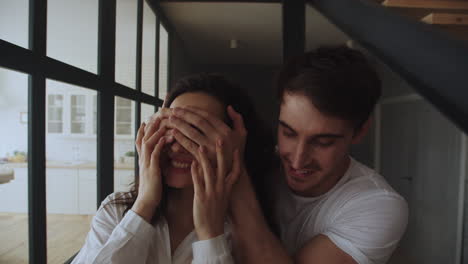 Happy-family-couple-entering-home-in-slow-motion.-Portrait-of-hugging-couple