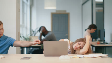 Tired-woman-sleeping-with-notebook-at-coworking-office