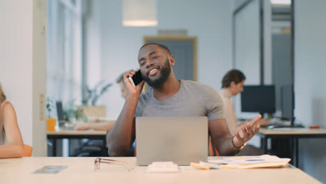 Happy-business-man-talking-phone-at-coworking-space.-Young-guy-having-phone