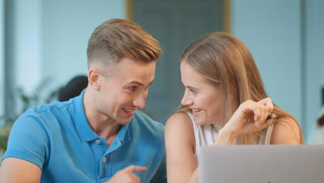 Happy-couple-talking-at-coworking.-Closeup-smiling-guy-flirting-with-blonde-girl