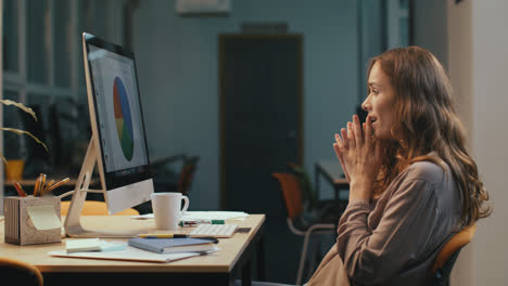 Surprised-business-woman-looking-at-financial-report-on-computer-screen-at-night