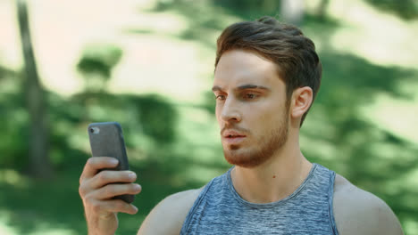 Sport-man-looking-mobile-phone-and-running-in-park.-man-Athlete-using-smartphone