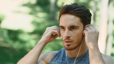 Sport-man-using-headphones-for-listening-music-on-morning-run-in-park