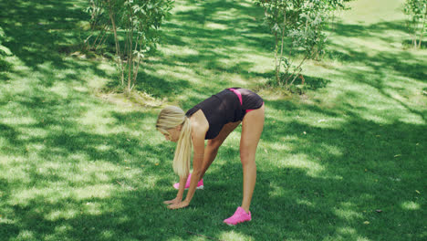 Athlete-woman-doing-stretching-slopes-down-before-fitness-workout-in-park