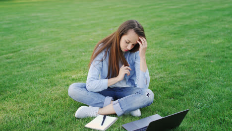 Thoughtful-woman-study-online-on-laptop-computer-in-summer-park