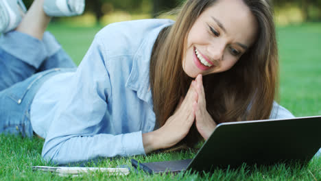 Happy-woman-looking-at-email-with-good-news-on-laptop-computer-in-park