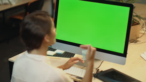 Business-woman-call-video-online-on-computer-with-green-screen-in-office