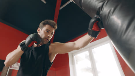 Kickboxer-man-making-strikes-at-fight-training.-Sportsman-having-cardio-training