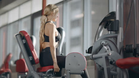 Fit-woman-doing-fitness-exercise-on-sport-simulator-in-modern-fitness-gym.