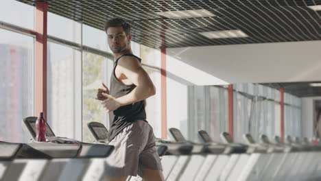 Runner-man-training-on-treadmill-machine-at-workout-in-fitness-center