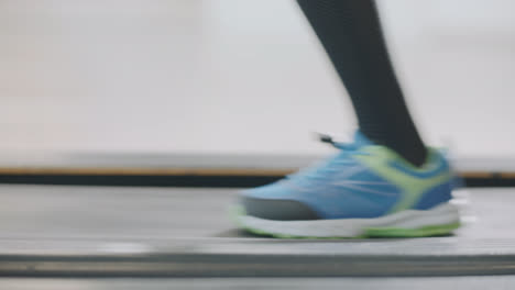 Closeup-running-legs-on-treadmill-in-fitness-gym.