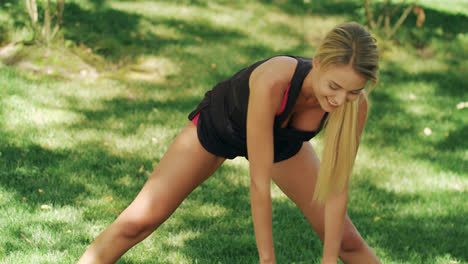 Happy-woman-enjoying-fitness-training-outdoor.-Cheerful-woman-stretching-legs