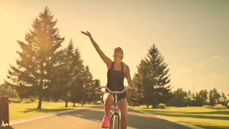 Young-woman-cycling-on-bicycle-in-summer-park.-Happy-woman-riding-bicycle