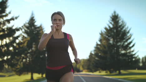 Sport-woman-running-on-park-road-at-summer.-Female-runner-training-outdoor