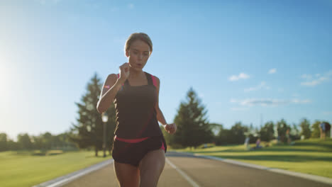 Woman-runner-running-in-slow-motion.-Sport-woman-running-on-park-road