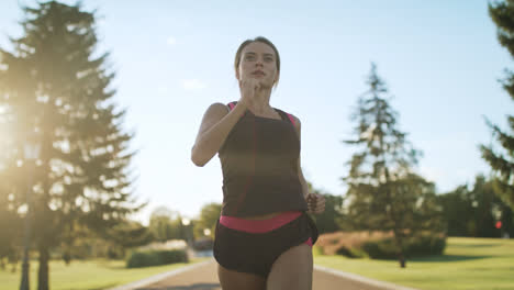 Athlete-woman-jogging-in-park.-Female-runner-breathing-hard-at-outdoor-training