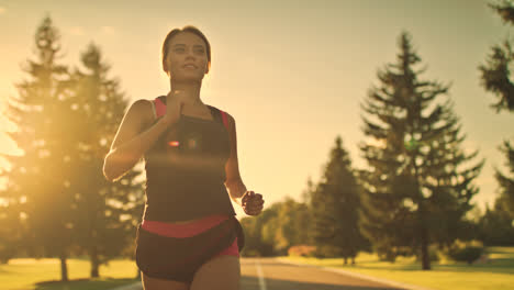 Sport-woman-running-at-sunset.-Female-runner-at-outdoor-workout-in-park