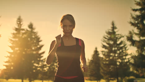 Young-woman-runner-running-in-park-at-sunset.-Fitness-woman-jogging-in-park