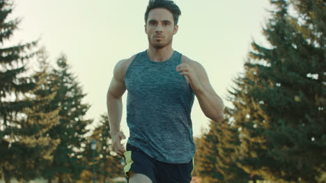 Young-man-running-in-park.-Sport-man-jogging-outdoor.-Tired-runner-stop