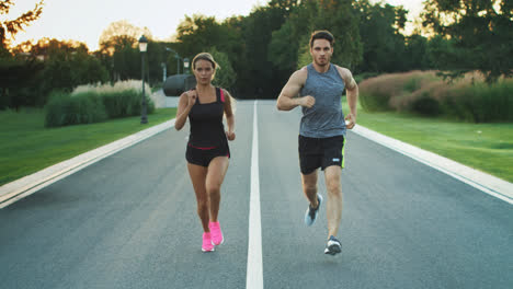 Sport-couple-run-together-in-park.-Young-people-jogging-together
