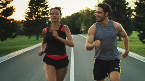 Sport-people-running-in-park-together.-Young-couple-jogging-at-outdoor-workout