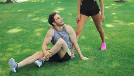 Sport-woman-help-boyfriend-to-warm-up-before-workout-outdoor