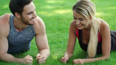 Fitness-couple-training-plank-workout-giving-five-after-finish-in-summer-park
