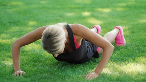 Fitness-woman-training-push-ups-exercise-on-grass-in-summer-park