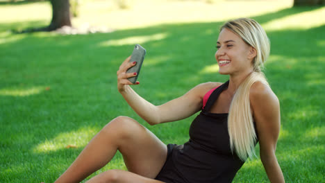 Sport-woman-taking-selfie-photo-on-mobile-phone-in-summer-park