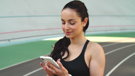 Fitness-Frau-Schaut-Draußen-Auf-Ihr-Smartphone.-Läuferin-Benutzt-Telefon