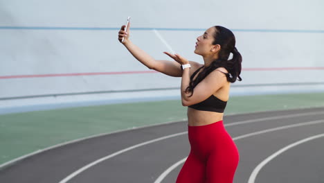 Runner-woman-taking-selfie-photo-on-mobile-phone-at-modern-track