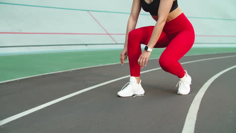 Sport-woman-lacing-up-sneakers-for-workout-on-track.-Woman-runner-tying-up-shoes