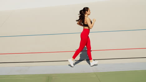 Fit-woman-jogging-on-stadium-track.-Woman-runner-running-in-slow-motion
