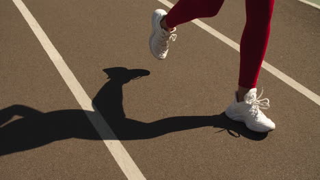Closeup-female-feet-running-on-stadium-track.-Woman-runner-jogging-on-track