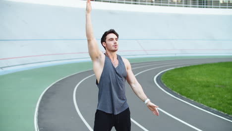 Male-runner-warming-up-before-running-workout-on-track.-Fit-man-stretching-hands