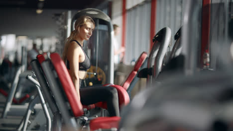 Beautiful-woman-doing-fitness-exercise-on-sport-simulator-in-gym-club.