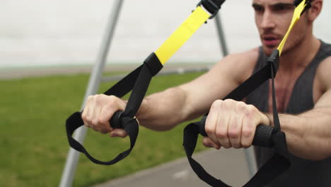 Closeup-man-working-out-with-trx-fitness-rope.-Guy-training-with-suspension-rope