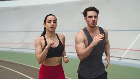 Fitness-couple-running-on-athletics-track.-Sport-couple-training-together