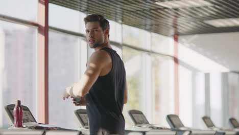 Handsome-man-walking-on-treadmill-machine-in-fitness-club.