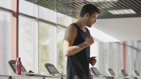 Fitness-man-running-on-treadmill-machine-in-gym-club.