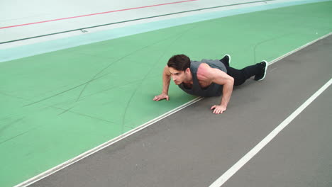 Fitness-man-doing-push-ups-in-slow-motion-at-stadium-outdoor