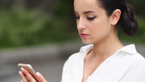 Closeup-girl-using-mobile-phone-outdoors.-Businesswoman-using-phone-after-work