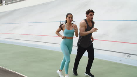Fitness-couple-training-together-at-modern-stadium.-Sporty-couple-running
