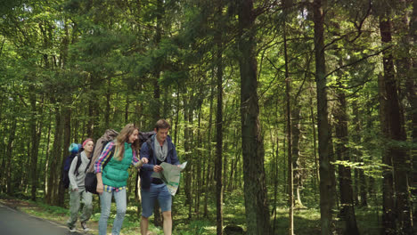Tourists-walking-in-wood.-Friends-study-way-on-map-while-traveling.-Summer-forest