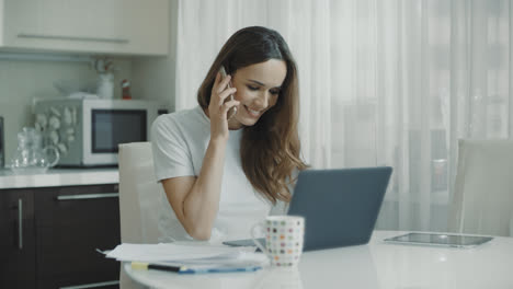 Business-woman-using-laptop-computer-at-home.-Professional-call-mobile-phone