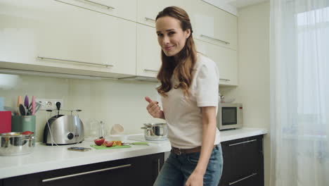 Woman-posing-in-front-of-camera.-Happy-girl-cooking-dinner-at-home