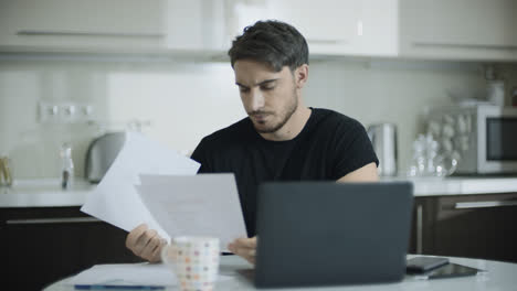 Worried-business-man-looking-papers-at-home-workspace.-Portrait-of-upset-man