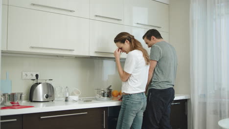Happy-couple-cooking-together-at-home.-Man-and-woman-having-fun-at-kitchen.