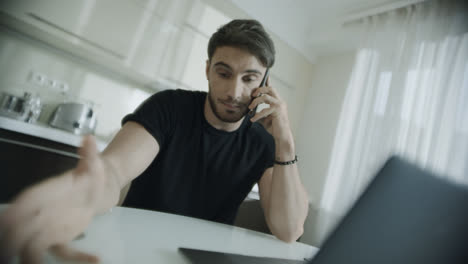 Angry-man-talking-mobile-phone-at-home.-Frustrated-entrepreneur